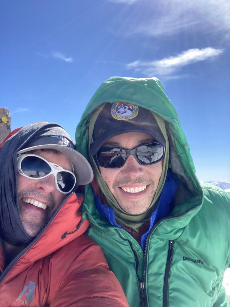 Friends celebrating a snowy mountain climb