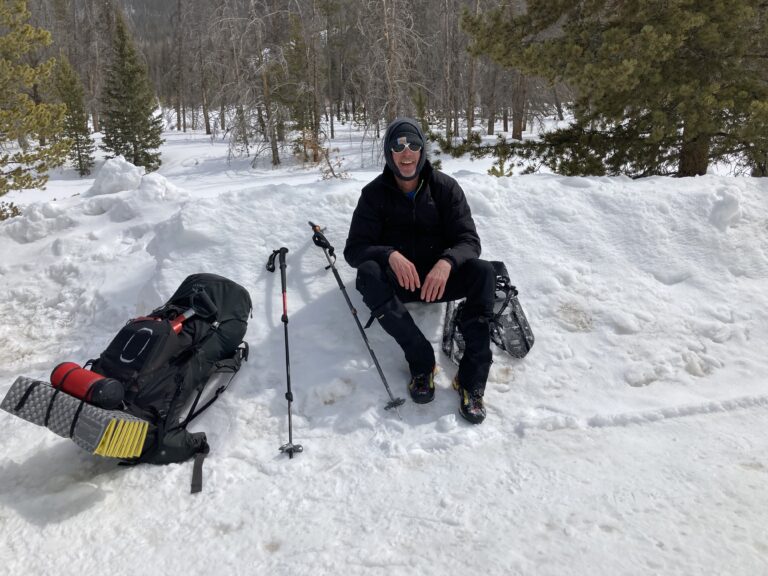 Man rests from mountain climbing in the snow